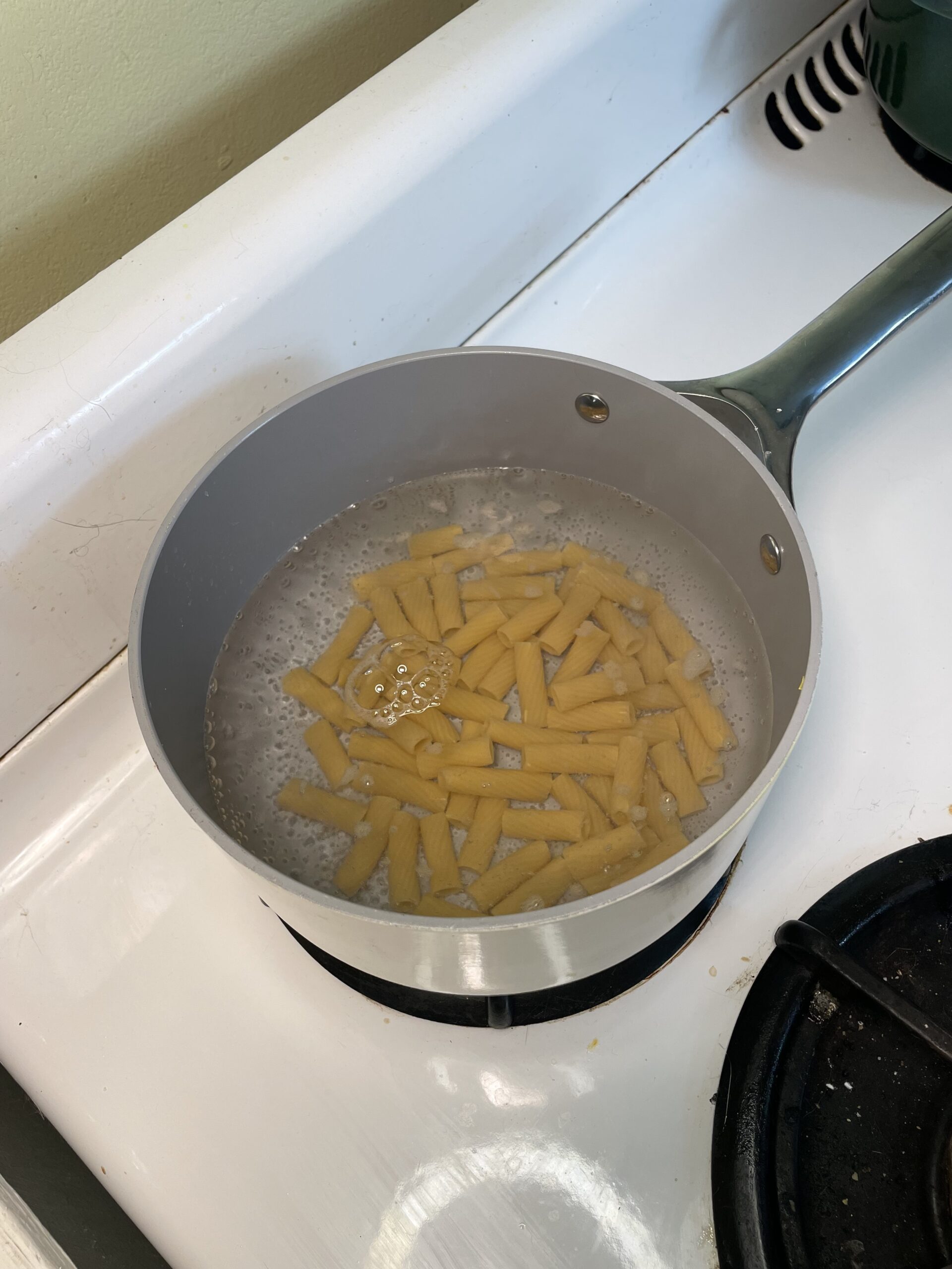 Pasta boiling in a pot of water on a stovetop, cooking until perfectly al dente.