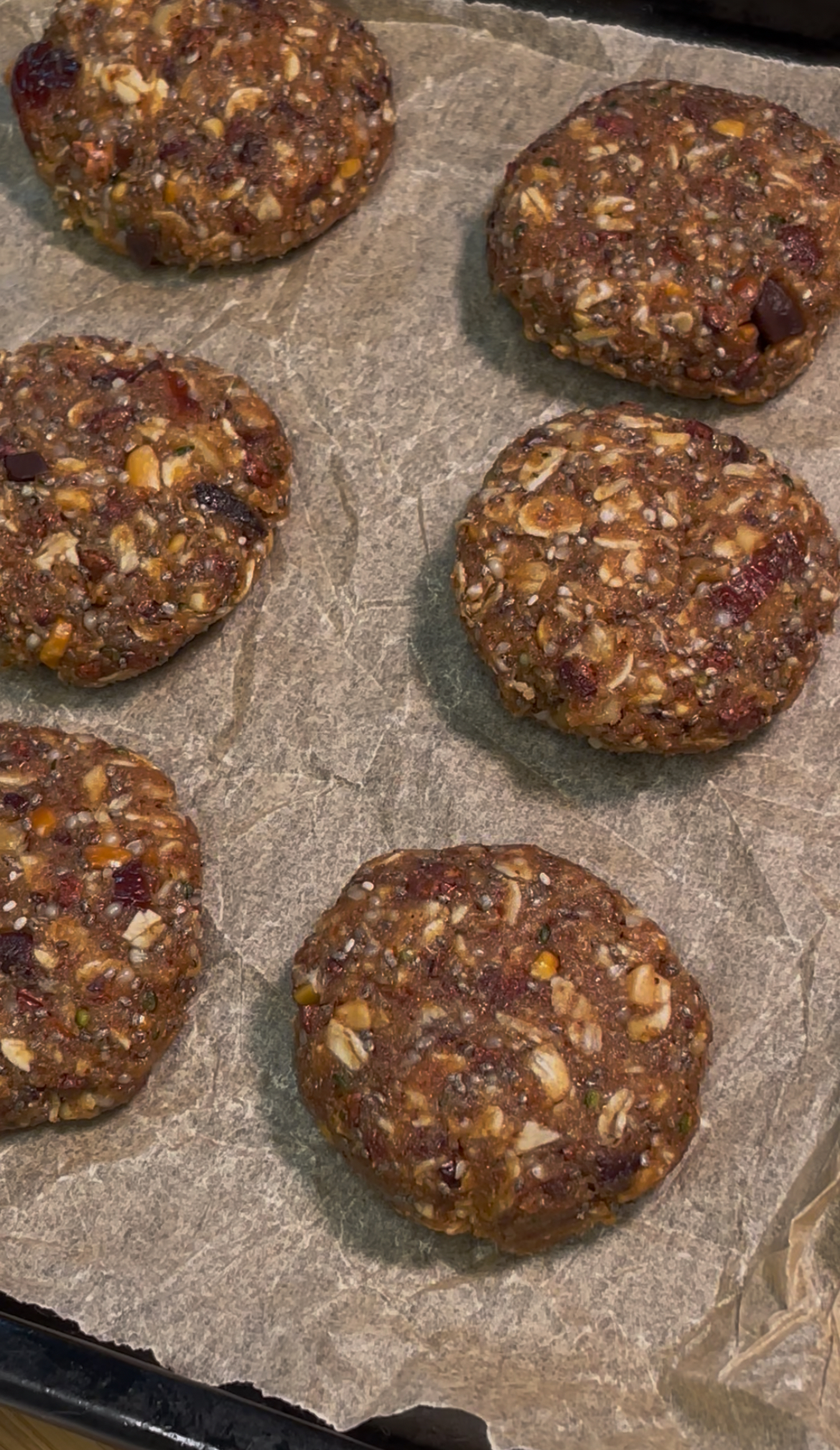 Oat and flax seed cookie dough rolled into small balls and distributed on a baking sheet lined with parchment paper.